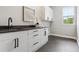 This laundry room offers plenty of counter space, cabinets, and a view of the outdoors at 7778 Windwood Way, Parker, CO 80134