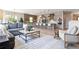 Open-concept living room with hardwood floors, a modern kitchen, and ample seating at 7778 Windwood Way, Parker, CO 80134