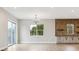 Modern living room with hardwood floors, sliding doors, and a brick accent wall with shelving at 7778 Windwood Way, Parker, CO 80134