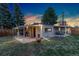 Spacious backyard featuring a covered patio, grill, and lush green grass, perfect for outdoor living at 109 S Fulton Ave, Fort Lupton, CO 80621