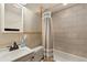 Tiled bathroom with shower-tub combo, single sink vanity, and neutral color palette at 109 S Fulton Ave, Fort Lupton, CO 80621