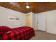 Bedroom featuring a rustic wood ceiling, closet, window, carpet, and exterior door at 109 S Fulton Ave, Fort Lupton, CO 80621
