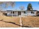 Exterior back of home with a patio, sliding glass door, and fenced yard on a sunny day at 6880 W Airview Ave, Lakewood, CO 80232
