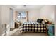 Cozy bedroom featuring a Buffalo plaid bedspread, side chair, and natural light at 6880 W Airview Ave, Lakewood, CO 80232