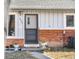 Close-up of the front door with brick trim, plants, and the house number visible at 6880 W Airview Ave, Lakewood, CO 80232
