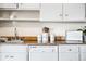 Cozy kitchen featuring white cabinets, granite countertops, a sink and decorative canisters at 6880 W Airview Ave, Lakewood, CO 80232