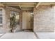 Unit 11 has a front door with a brick facade, covered porch, and an outdoor potted plant at 2670 E Otero Pl # 11, Centennial, CO 80122