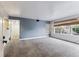 Living room with neutral carpet, blue accent wall, large windows, and white trim at 2670 E Otero Pl # 11, Centennial, CO 80122