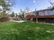 Expansive backyard with a large grassy area, patio, and deck, offering ample space for outdoor activities and relaxation at 416 Pluto Ct, Lone Tree, CO 80124