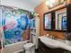 Colorful bathroom with floral shower curtain, vanity with sink, and mirrored cabinet at 416 Pluto Ct, Lone Tree, CO 80124
