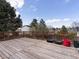 Wooden deck area with a red painted railing offers a view of the partially fenced backyard and the neighborhood at 416 Pluto Ct, Lone Tree, CO 80124