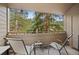 Outdoor balcony with chairs and views of surrounding green landscape and mature trees at 23551 Genesee Village Rd # H, Golden, CO 80401