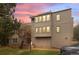 Three-story townhome showcasing large windows and exterior architectural details against a vibrant sunset backdrop at 23551 Genesee Village Rd # H, Golden, CO 80401