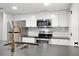 Modern kitchen with stainless steel appliances, white cabinets, and stone countertops at 23551 Genesee Village Rd # H, Golden, CO 80401