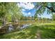 Picturesque pond surrounded by trees, offering a tranquil and scenic natural feature for residents to enjoy at 23551 Genesee Village Rd # H, Golden, CO 80401