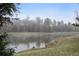 Scenic view of pond, with lush landscaping and trees creating a tranquil, serene setting at 23551 Genesee Village Rd # H, Golden, CO 80401