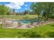 Outdoor pool surrounded by lounge chairs, perfect for relaxation and enjoying sunny days with community buildings in background at 23551 Genesee Village Rd # H, Golden, CO 80401