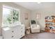 Cozy Bedroom with a changing table, rocker, and bookshelf filled with toys and books at 3529 S Telluride Cir # D, Aurora, CO 80013