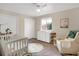 Charming Bedroom featuring a crib, changing table, and cozy rocking chair at 3529 S Telluride Cir # D, Aurora, CO 80013