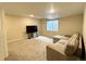 Finished basement offers living space with television, gray sofa, and natural light from the window at 25206 E Lake Dr, Aurora, CO 80016