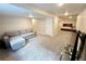 Finished basement includes a living area with gray couch and view of the carpeted bedroom at 25206 E Lake Dr, Aurora, CO 80016