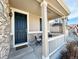 Cozy front porch with a seating area, stone accents, and a welcoming entrance to the home at 25206 E Lake Dr, Aurora, CO 80016