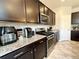 Well-equipped kitchen featuring granite countertops, stainless steel appliances, and dark wood cabinets at 25206 E Lake Dr, Aurora, CO 80016