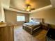 Comfortable bedroom featuring a wooden bed frame, ceiling fan and neutral tones at 25206 E Lake Dr, Aurora, CO 80016