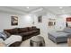 Spacious basement with a brown sofa, gray chaise, round coffee table, and guitars on the wall at 2248 S Lincoln St, Denver, CO 80210