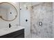 Modern bathroom features a round mirror, sleek vanity, and a stylish shower with decorative tiles at 2248 S Lincoln St, Denver, CO 80210