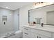 Modern bathroom featuring quartz countertops, a large mirror, and a glass-enclosed shower at 2248 S Lincoln St, Denver, CO 80210