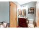 Bathroom with vanity, sink, toilet and storage for towels and necessities at 9565 W Coal Mine Ave # A, Littleton, CO 80123
