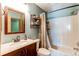 Well lit bathroom with a wood framed mirror, stone vanity and bath with shower at 9565 W Coal Mine Ave # A, Littleton, CO 80123