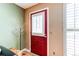 Inviting entryway featuring a vibrant red door, neutral walls, and a view of the window with white blinds at 9565 W Coal Mine Ave # A, Littleton, CO 80123