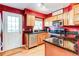 Red accent wall highlights the light wooden cabinets, stainless appliances, and dark countertops at 9565 W Coal Mine Ave # A, Littleton, CO 80123