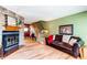 Warm living room featuring a stone fireplace, comfortable seating, and staircase leading to the upper level at 9565 W Coal Mine Ave # A, Littleton, CO 80123