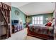 Comfortable main bedroom featuring a TV, tasteful decor, a large bed, and a bright window at 9565 W Coal Mine Ave # A, Littleton, CO 80123
