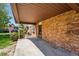 View of covered patio, showcasing brick accents with a spacious backyard and mature trees creating a serene outdoor space at 1354 S Macon St, Aurora, CO 80012
