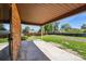 Covered patio overlooking a spacious backyard with lush green grass and mature trees, perfect for outdoor activities at 1354 S Macon St, Aurora, CO 80012