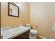 Classic bathroom featuring a vanity with white sink and a toilet with patterned wall paper at 1354 S Macon St, Aurora, CO 80012
