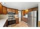 Functional kitchen featuring wooden cabinets, stainless steel appliances, and laminate flooring at 1354 S Macon St, Aurora, CO 80012