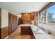 A traditional-style kitchen with wooden cabinets, laminate flooring, and a stainless steel sink at 1354 S Macon St, Aurora, CO 80012