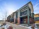 Modern townhome with brick and green siding, private balcony, and snow-covered walkway at 11267 Central Ct, Broomfield, CO 80021