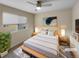 Virtually staged bedroom with neutral tones, wood platform bed, and ceiling fan at 11267 Central Ct, Broomfield, CO 80021