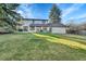 Expansive backyard featuring a patio with seating, a lush lawn, and mature trees, perfect for outdoor enjoyment at 3930 S Hillcrest Dr, Denver, CO 80237