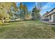 Expansive, grassy backyard with mature trees provides a serene outdoor space at 3930 S Hillcrest Dr, Denver, CO 80237