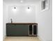 Modern basement bar features a sleek cabinet with a wine fridge and a stylish countertop sink at 3930 S Hillcrest Dr, Denver, CO 80237
