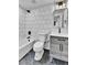 Renovated bathroom features white subway tiles, modern vanity with black accents, and marble-look floor at 3930 S Hillcrest Dr, Denver, CO 80237