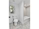 Bright bathroom with a window, gray tile, and modern fixtures at 3930 S Hillcrest Dr, Denver, CO 80237