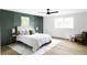 Bright bedroom featuring an accent wall, ceiling fan, and hardwood floors at 3930 S Hillcrest Dr, Denver, CO 80237